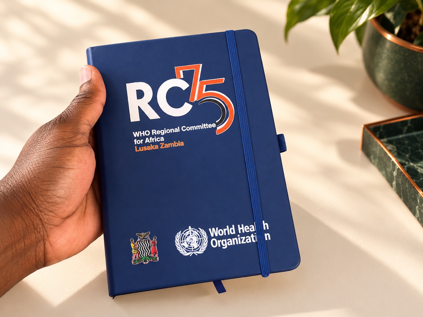 Styled presentation of a WHO RC75 branded diary based on Planet Jobbing's project photo